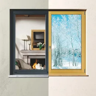 bicoloration_fenetre_tryba.webp Cette image montre une fenêtre divisée mettant en contraste un intérieur chaleureux avec cheminée et un extérieur hivernal enneigé.