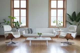Facteur_solaire_Sw.webp Un salon lumineux et minimaliste avec un canapé blanc, deux fauteuils modernes, une table basse, et des plantes vertes devant de grandes fenêtres en