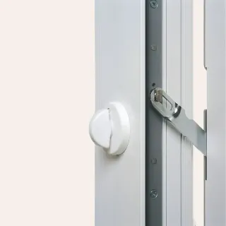 fenetre_entrebailleur.webp Un verrou de fenêtre blanc est solidement installé sur un cadre métallique.