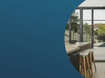 Un espace intérieur moderne s'ouvrant sur une terrasse avec piscine, visible à travers une baie vitrée.