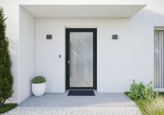 Entrée moderne avec une porte vitrée encadrée de noir, flanquée de deux appliques murales et entourée d'une végétation