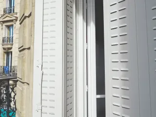 volet_persienne.webp Volet pliant blanc sur balcon pour une façade au style traditionnel