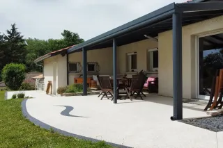 pergola_volutive_a_toit_fixe_personnalisable.webp Terrasse moderne avec pergola en aluminium et mobilier en bois, offrant un espace de détente extérieur spacieux et ombragé.