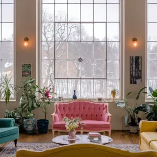 point_thermique_fenetre_isolation.webp Un salon lumineux avec de grandes fenêtres, décoré de canapés colorés et de plantes d'intérieur.