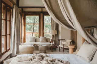 pont_thermique_chambre.webp Une chambre lumineuse et élégante avec des fenêtres en bois, des rideaux légers, et un intérieur aux tons naturels.