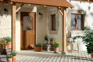 style_maison_fenetre_couleur_tryba_choisir.webp Entrée de maison accueillante avec une porte en bois, entourée de pots de fleurs et de plantes sous un porche en bois clair.