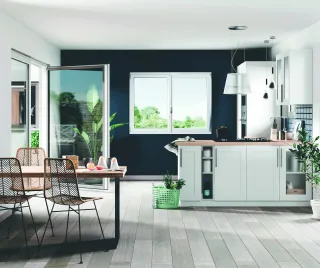 T81_CUISINE.webp Cuisine moderne avec des meubles blancs, un mur bleu foncé, et des touches de décoration végétale.