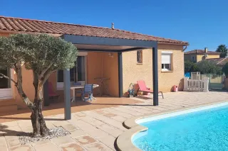 toit_fixe_pergola.webp Une villa ensoleillée avec piscine, terrasse ombragée et un olivier sur un fond de ciel bleu.
