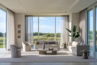 triple_vitrage_luminosit.webp Un salon moderne et lumineux avec de grandes baies vitrées donnant sur une vue verdoyante.