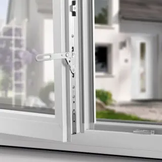 utilisation.webp Fenêtre blanche en PVC avec un système de sécurisation, ouverte sur un extérieur flou d'une maison moderne.