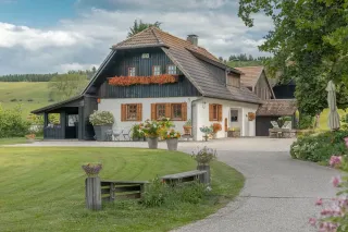 Volet_Rsistance_thermique.webp Cette charmante maison de campagne, entourée de verdure et ornée de fleurs colorées, offre un cadre paisible et pittoresque.